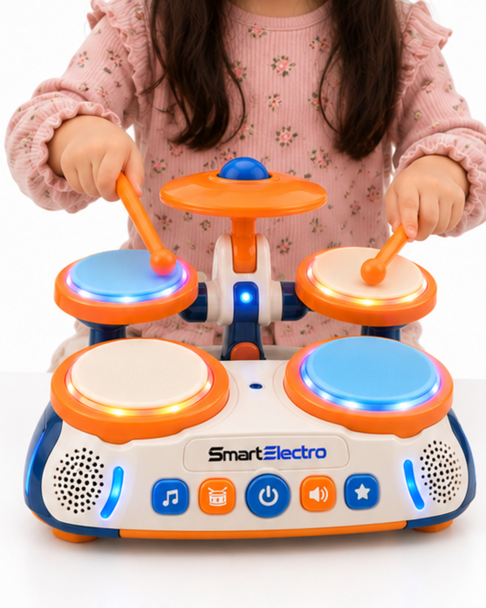 Child drumming on the raised pads of the bright orange toy drum set